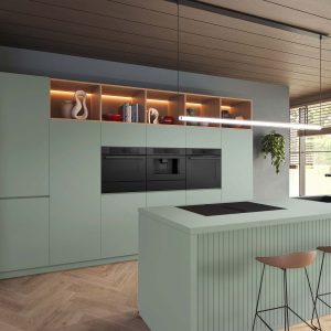 Elegante mintfarbene Küche mit akzentuierter Beleuchtung der Insel und Regale von Bosch