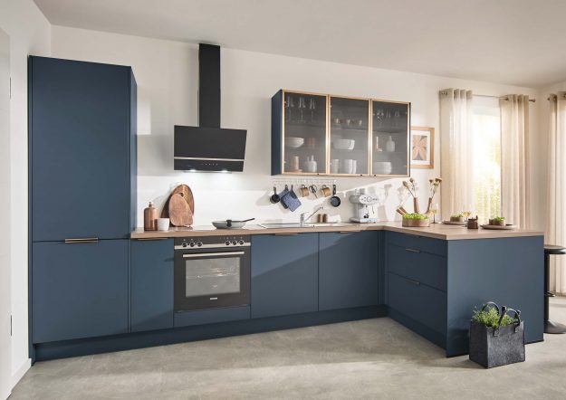 Klassische Küche von Häcker in L-Form mit dunkeblauen Fronten und Vitrinenschränken erhältlich bei Das Küchenstudio
